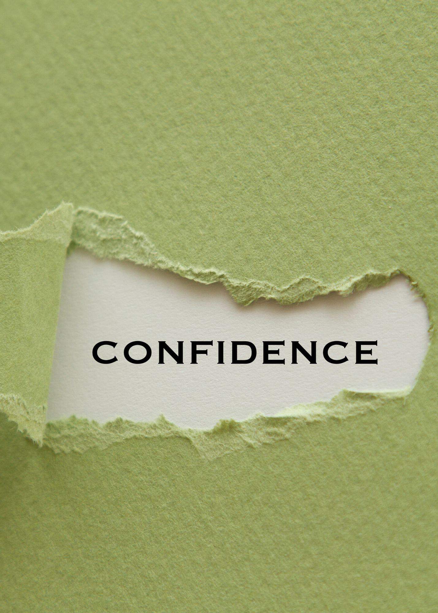 torn green craft paper with the word confidence showing