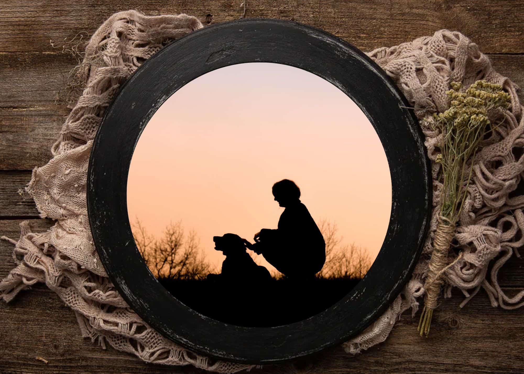 black barnwood round featuring a silhouette of a woman lovingly petting her pit bull at sunset
